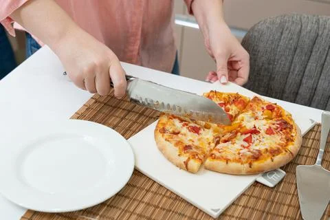 Separating slices of pizza on the table for dinner Stock Photos