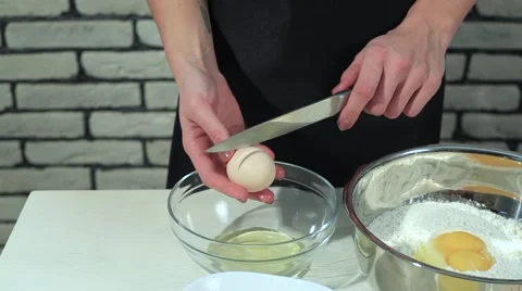 Separating yolk and white of the white shell egg with woman hands  Stock Footage 68909048