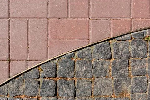 Separation of a metal strip of two types of pavers. View from above. Stock Photos