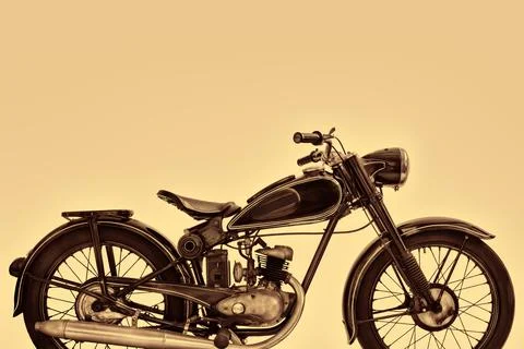 Sepia toned side view image of a vintage motorcycle Фото