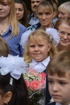 September 1, Knowledge Day. Smart children are standing near the school. Stock Photos