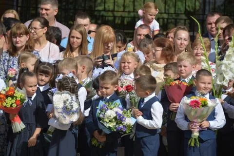 September 1, Knowledge Day. Smart children are standing near the school. Stock Photos