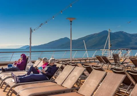 September 14, 2018 - Inside Passage, Alaska: Cruise passengers reading outdoo Stock Photos