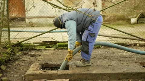 Septic cesspool pumping tank by suction hose under pressure worker Stock Footage 147213343