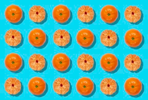 Sequence of a colorful pattern of whole peeled oranges on a blue background. Stock Photos