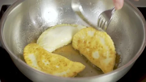 Sequence of fries being fried in heated oil in black pan and stirring them Stock Footage 140059791