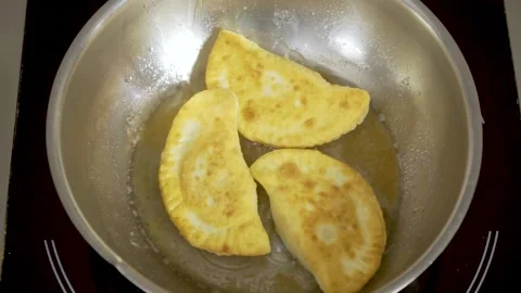 Sequence of fries being fried in heated oil in black pan and stirring them Stock Footage 140059807