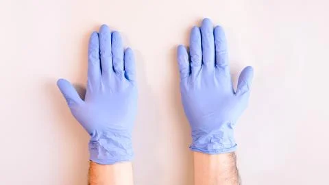 Sequence of images in which a man's hands taking off blue disposable gloves m Stock Photos