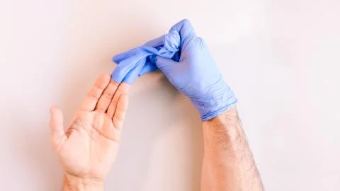 Sequence of images in which a man's hands taking off blue disposable gloves m Stock Photos