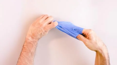 Sequence of images in which a man's hands taking off blue disposable gloves m Stock Photos