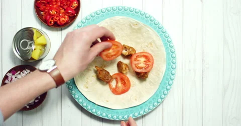 A sequence preparing a tortilla with different vegetables and chicken Stock Footage 61535319