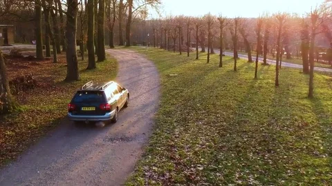 Sequence of stabilized aerial drone shots of a car driving towards the sun Stock Footage 84641713
