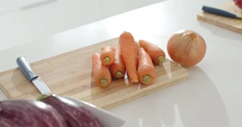 On sequence start, camera is shifting focus, revealing carrots on cutting board Stock Footage 344964398
