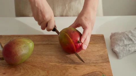 Sequence of Woman's hands cuts mangoes on cutting wooden Stock Footage 197157421