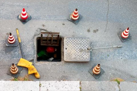 Sequence of worker going in the manhole in the street, step 4 Stock Photos