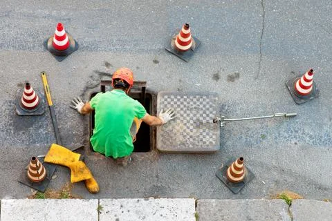 Sequence of worker going in the manhole in the street, step 2 Stock Photos