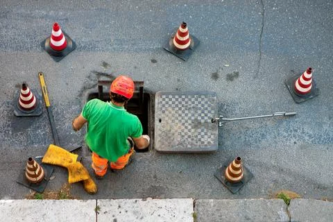 Sequence of worker going in the manhole in the street, step 1 Stock Photos