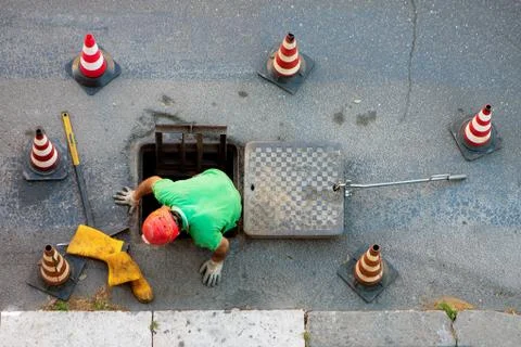 Sequence of worker going in the manhole in the street, step 6 Stock Photos