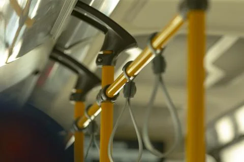 Sequential bus strap rows with vibrant poles and blurry background Stock Photos