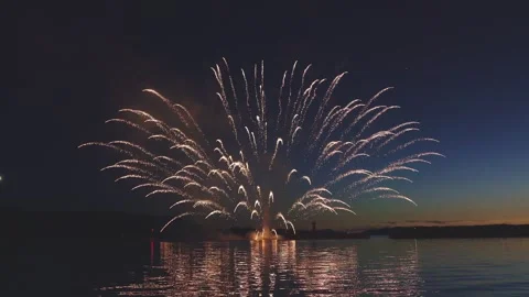 Sequential colorful fireworks launching from water in dusk sky over sea Stock Footage 340632732