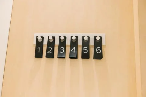 Sequential number tags on wall hooks for organization Stock Photos