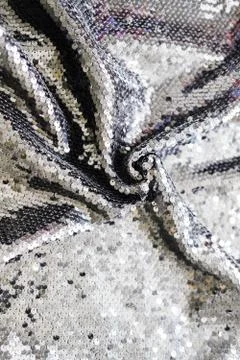 Sequin fabric texture. Shiny silver sparkling background. Clothing piece of Stock-Fotos