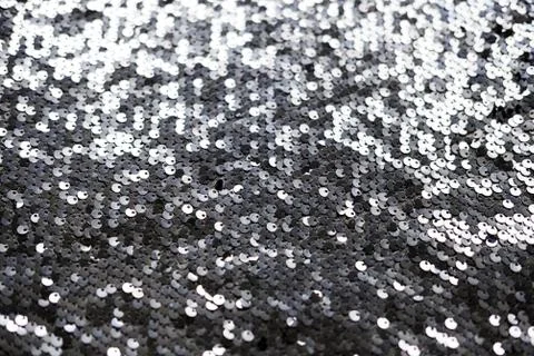 Sequin fabric texture. Shiny silver sparkling background. Clothing piece of Stock-Fotos
