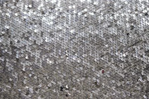 Sequin fabric texture. Shiny silver sparkling background. Clothing piece of Stock Photos