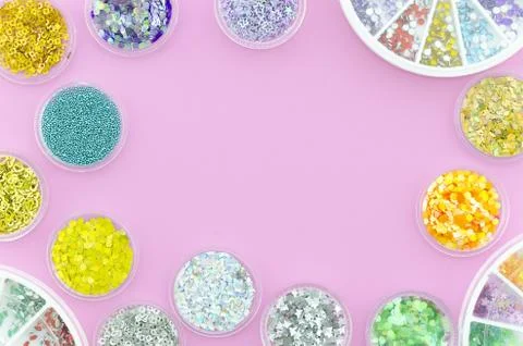 Sequins and glitters for nails in jars with border arrangement. Top view on a Stock Photos