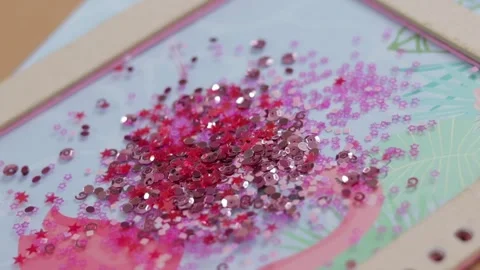 Sequins in pink colors falling on a pile, close up of arts and crafts Stock Footage 285540833