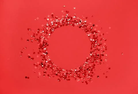 Sequins red confetti lined in round frame red background. Abstract festive Stock Photos