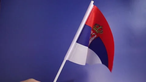 Serbian flag in hand on a blue background, independence national day of Ser.. Stock Footage 253577562