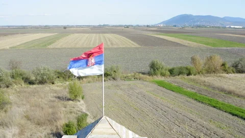 The Serbian flag at the top of the tower  in the middle of the field Vidéo 141521834