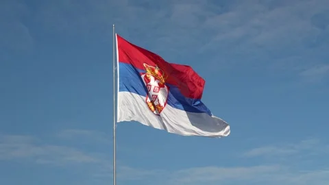 Serbian flag waving in slow motion against blue sky Stock Footage 318657034