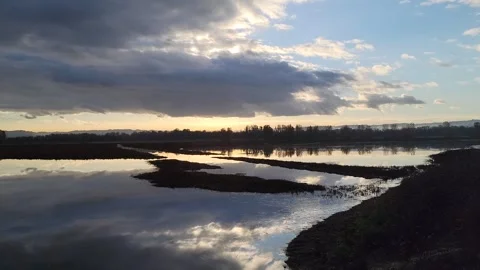 Serene 4K lake sunset with dramatic clouds and bright reflections near Vancouver 스톡 동영상 321404961
