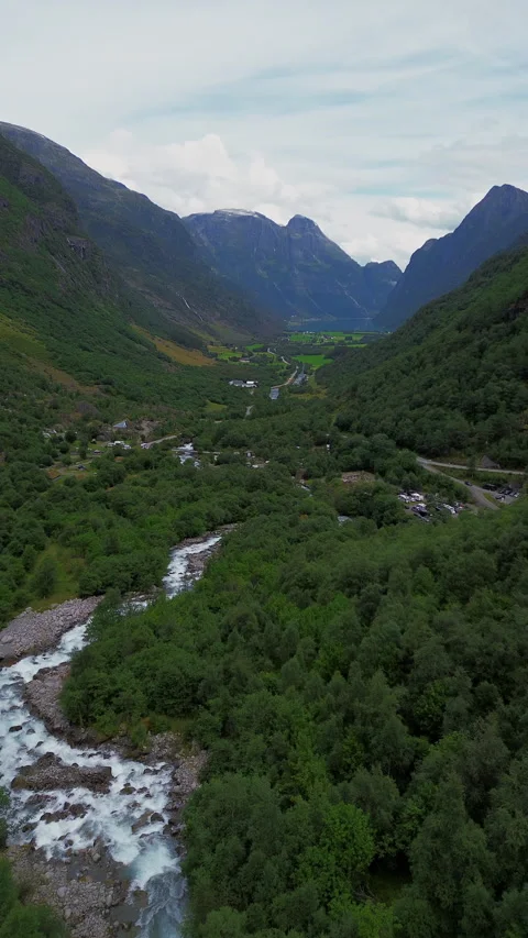 Serene 4K Mountain Stream Flowing Through a Lush Green Valley in Norway Vídeos de archivo 296014351