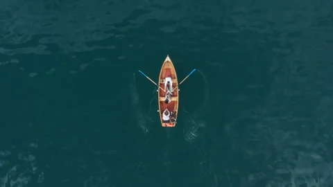 Serene aerial top-down view of a small boat on immense calm water Stock Footage 318547870