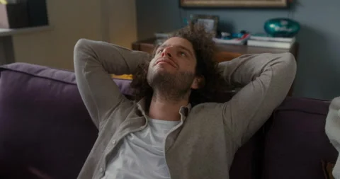 Serene attractive young guy resting on couch taking deep breath of fresh air Video stock 213326108