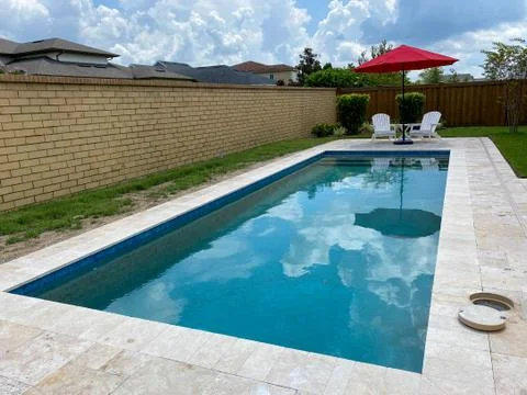 A serene backyard setting with a swimming pool a red umbrella Foto stock