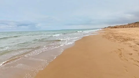A Serene Beach Featuring Gentle Waves Lapping Against the Soft, White Sand Stock Footage 303734653