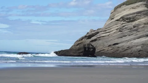 A Serene Beach Landscape Featuring Dramatic and Majestic Rock Formations Nearby Stock Footage 303479995