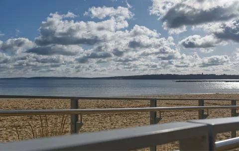 Serene Beach Scene with Clouds in blue sky and Calm Waters Stock Photos