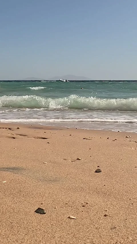 A Serene Beach Scene: Gentle Waves Lapping Against the Shore with Soft Sand and Stock Footage 330097030