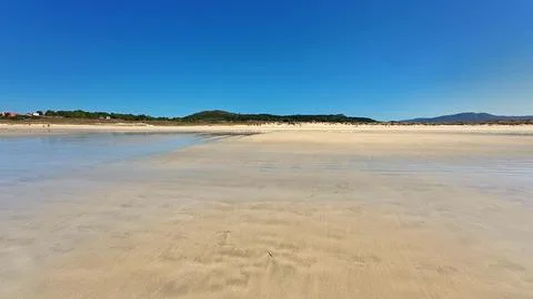 A Serene Beach Scene Set Under a Beautifully Clear Blue Sky, Perfect for Re.. Stock Photos
