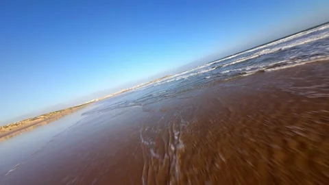 Serene beach scene with soft waves washing over sandy shore under bright sky Video stock 346075575