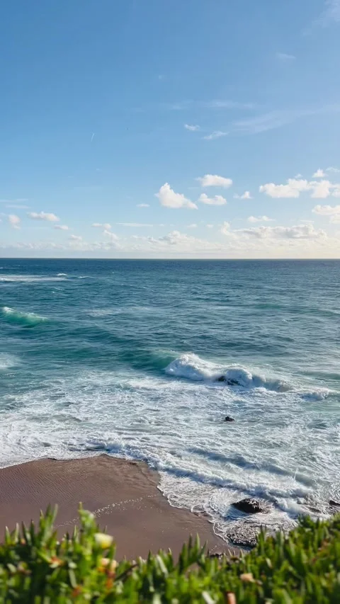 Serene Beach Scene with Waves and Clear Blue Sky Stock Footage 274388927