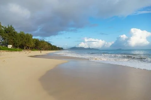 A serene beach setting with a backdrop of blue skies and fluffy clouds Stock-Fotos