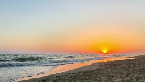 Serene Beach Sunset with Sea Waves and Warm Orange Sky Stock Footage 341915551