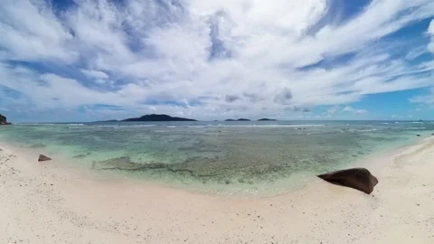 Serene beach with turquoise water and distant islands. Seychelles, La Digue. Stock Footage 303473182