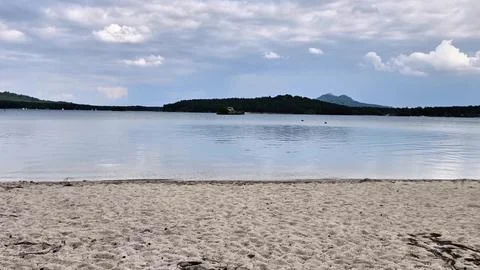 Serene Beach View Featuring Calm Waters and an Overcast Sky Perfect for Stock Photos